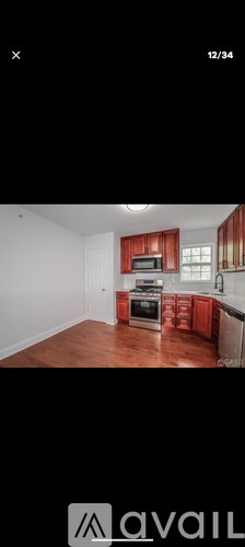 A kitchen with red cabinets and a white wall.