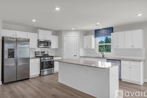 A modern kitchen with white cabinets and stainless steel appliances.