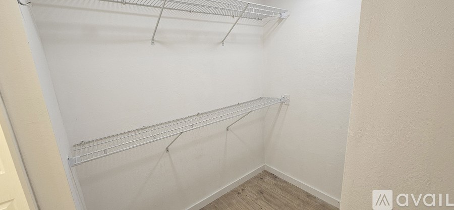 A white wall with a shelf and a door on the left.