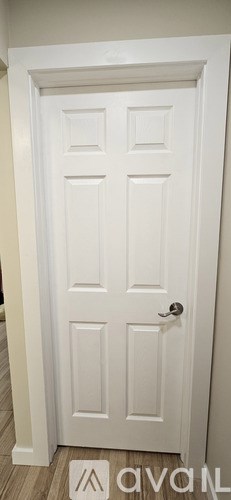 A white door with a handle and a doorknob.