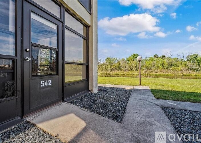 A modern house entrance with a glass door and a number 542 on it.