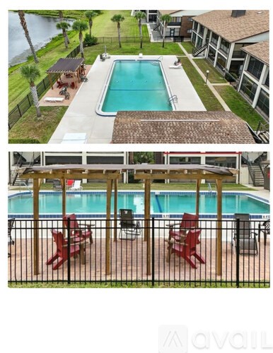 A pool surrounded by a black fence with red chairs.