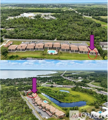 An aerial view of a resort with a swimming pool and a road.