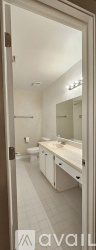 A bathroom with a toilet, sink, and mirror.