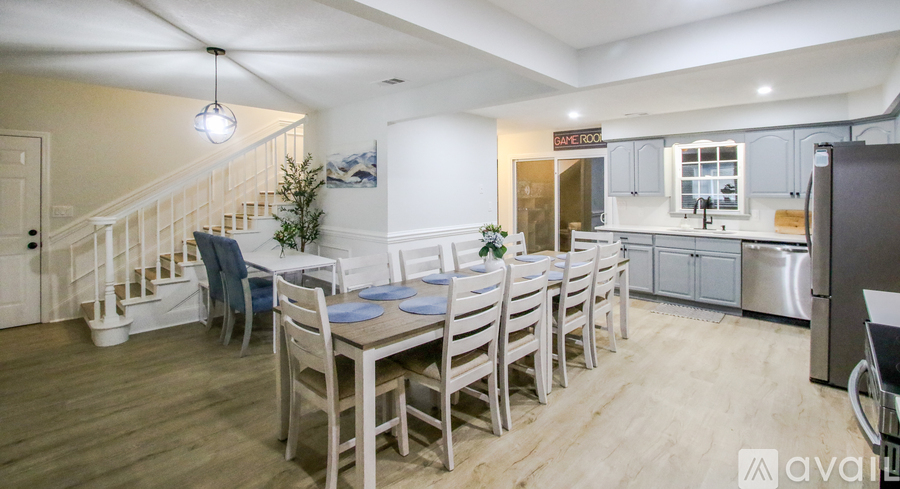A dining area with a table set for six with blue plates.