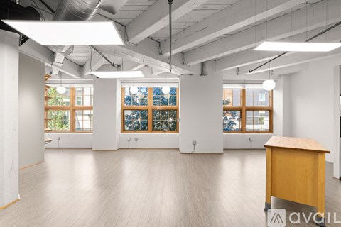 A spacious office room with a desk and large windows.