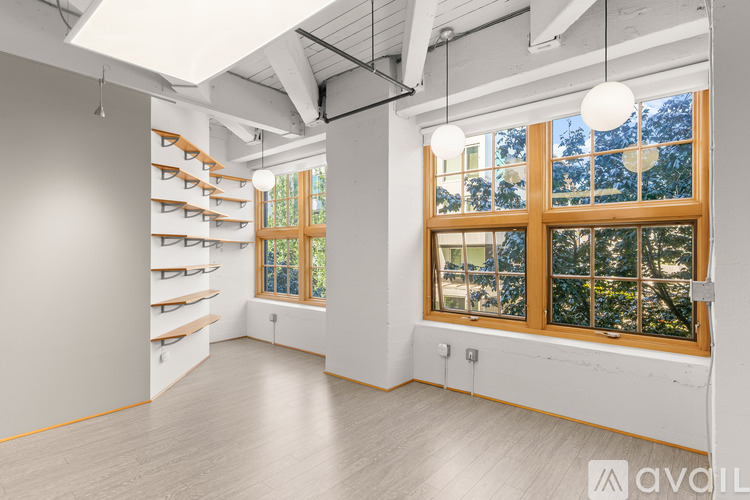 A room with a window and a wall of shelves.