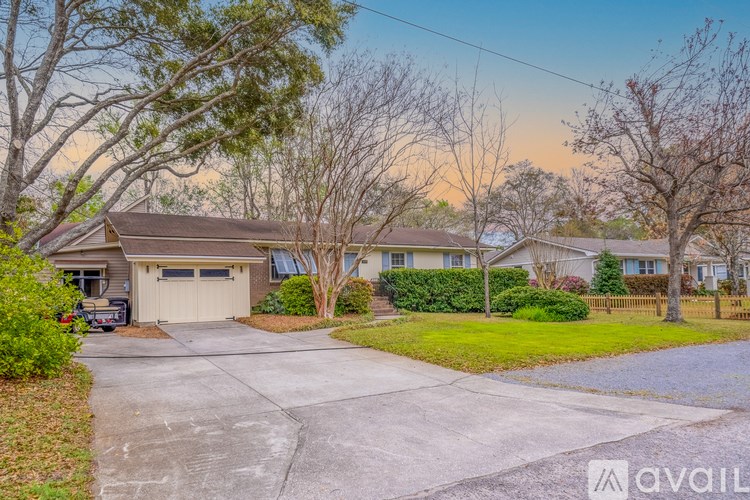 A house with a driveway and a tree in front.
