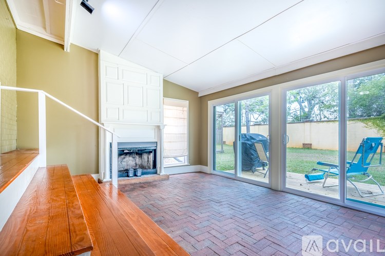 A room with a fireplace and sliding glass doors leading to a backyard.