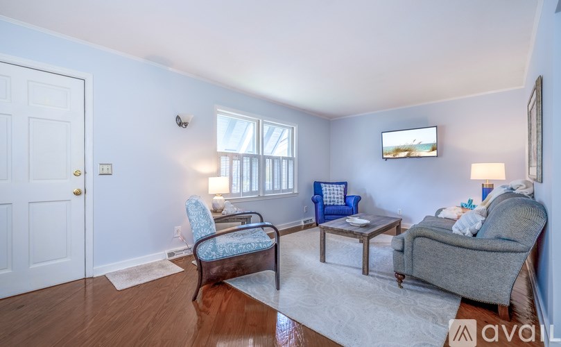 A living room with a blue chair and a grey couch.