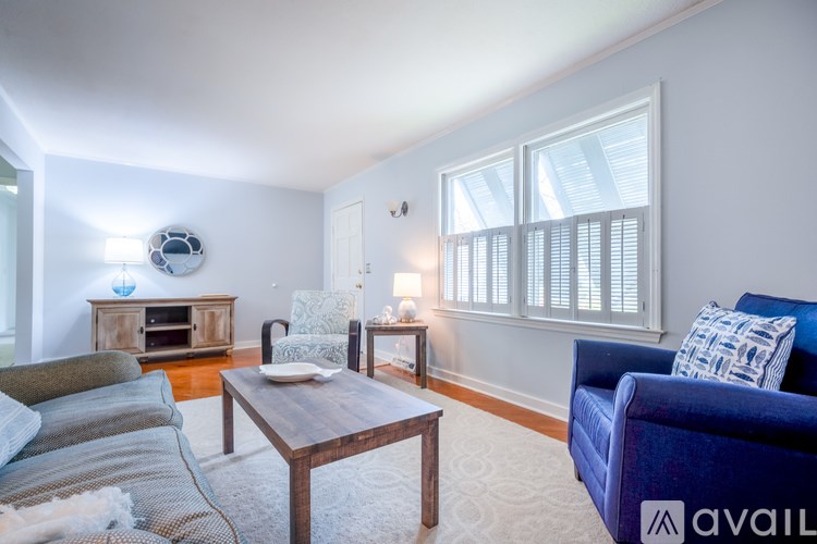 A living room with a blue couch and a wooden coffee table.