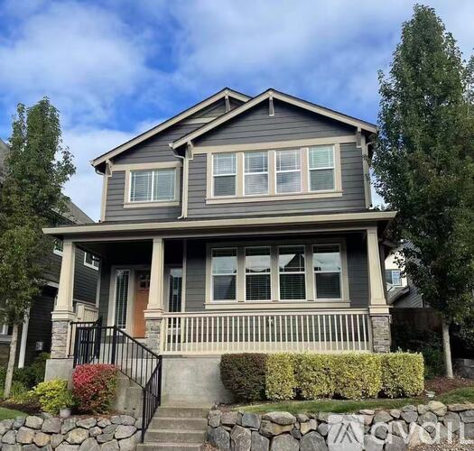 A house with a front porch and a stone wall.