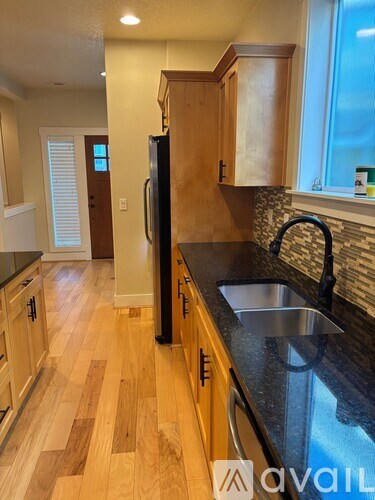A kitchen with wooden cabinets and a black countertop.