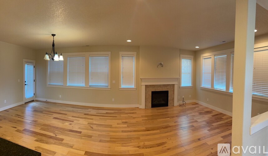 A spacious living room with a fireplace and wooden flooring.