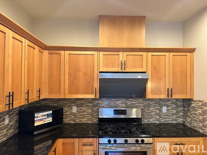 A kitchen with wooden cabinets and a black countertop.
