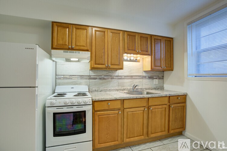 A kitchen with wooden cabinets and a white fridge.