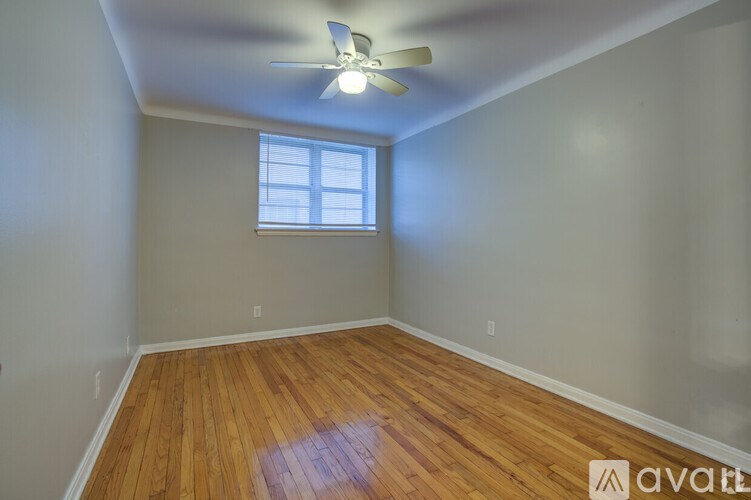 A room with wooden floors and a ceiling fan.
