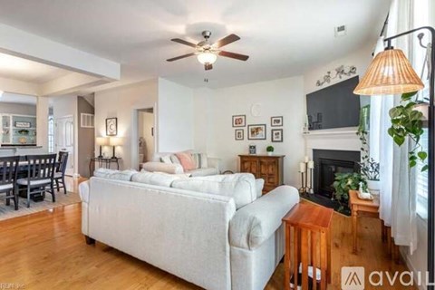 A living room with a white couch and a fireplace.