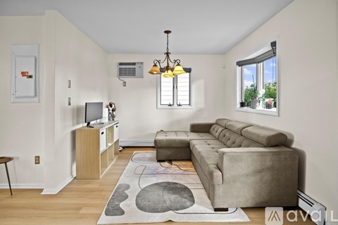 A living room with a grey couch and a wooden cabinet.