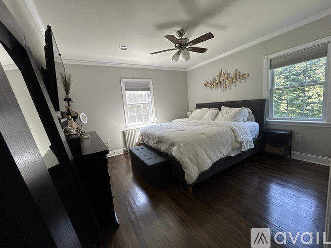 A bedroom with a large bed and a ceiling fan.