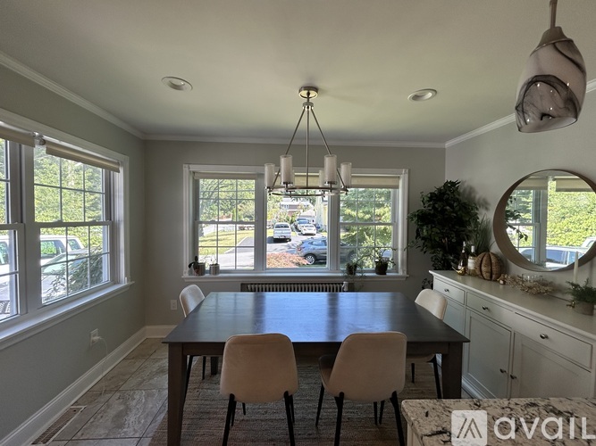 A dining room with a table and chairs.