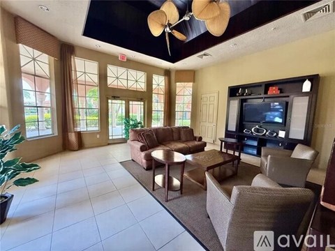 A living room with a television and a large window.