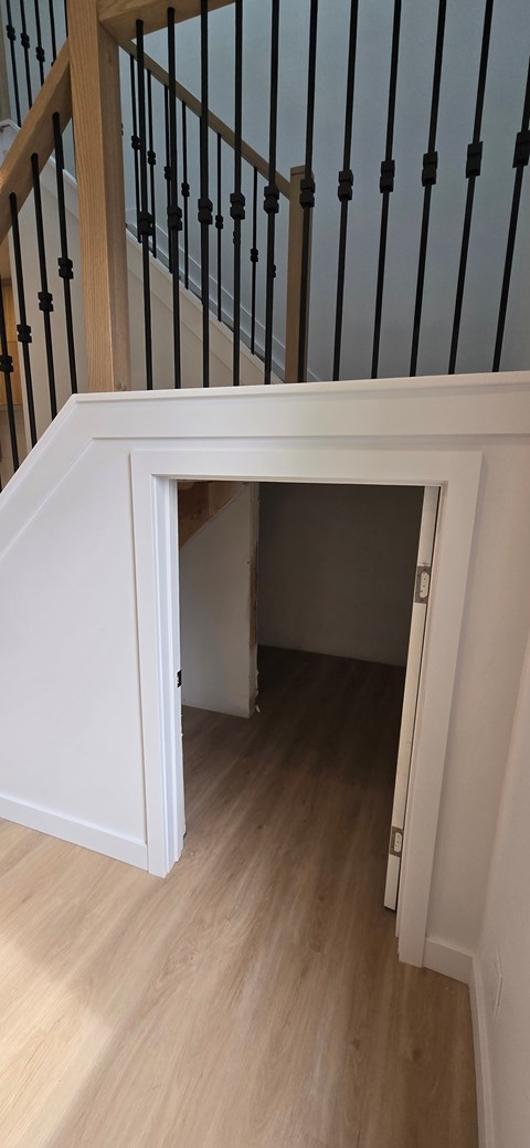 A staircase with a black railing and wooden steps.
