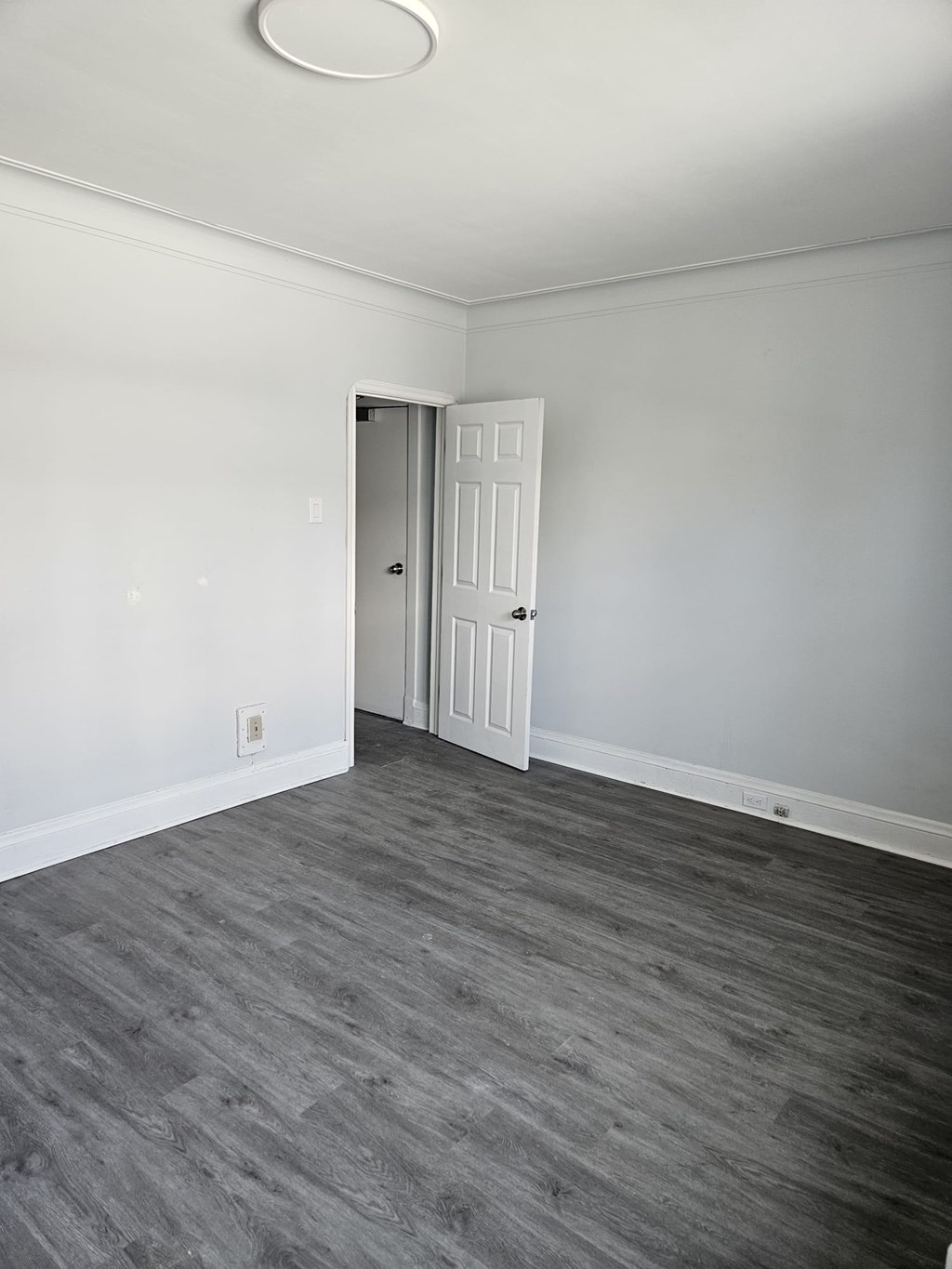 A room with a grey floor and a white door.