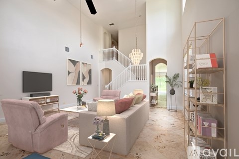 A living room with a pink chair and a white sofa.