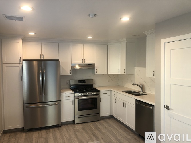A modern kitchen with stainless steel appliances and white cabinets.