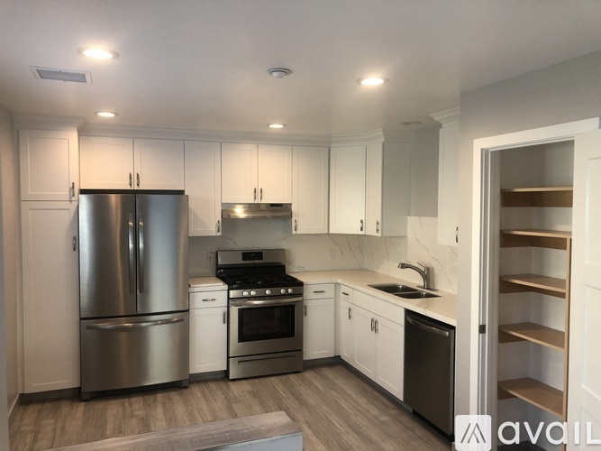 A kitchen with a refrigerator, stove, and oven.