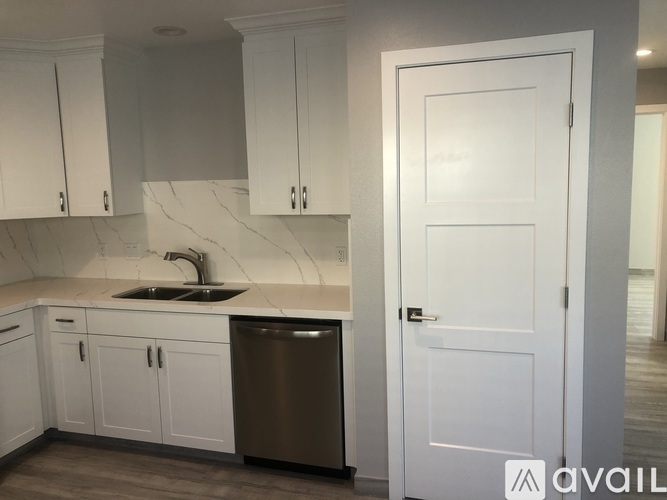 A kitchen with white cabinets and a sink.
