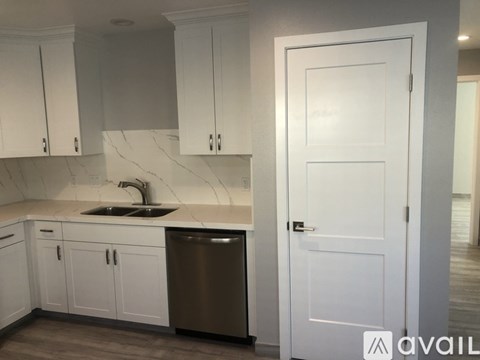 A kitchen with white cabinets and a sink.