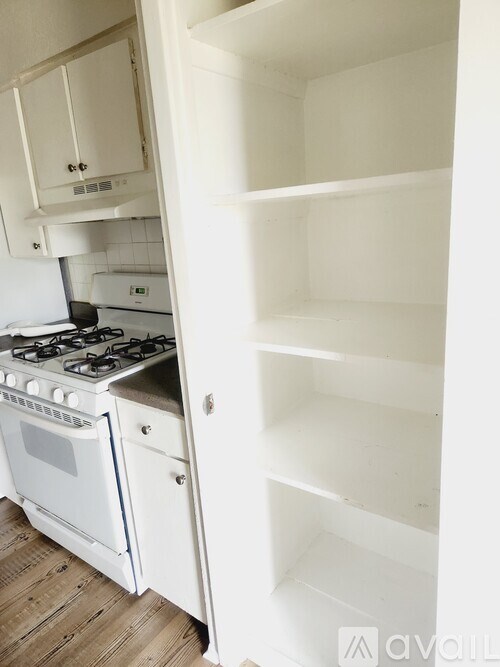 A white kitchen with an open refrigerator.