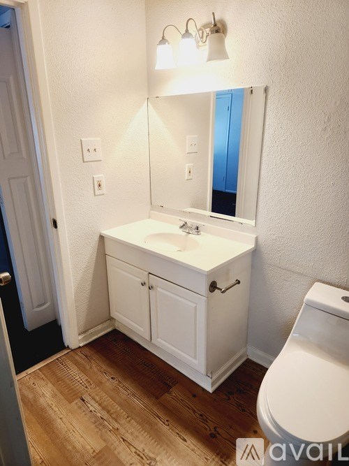 A white bathroom with a sink and toilet.