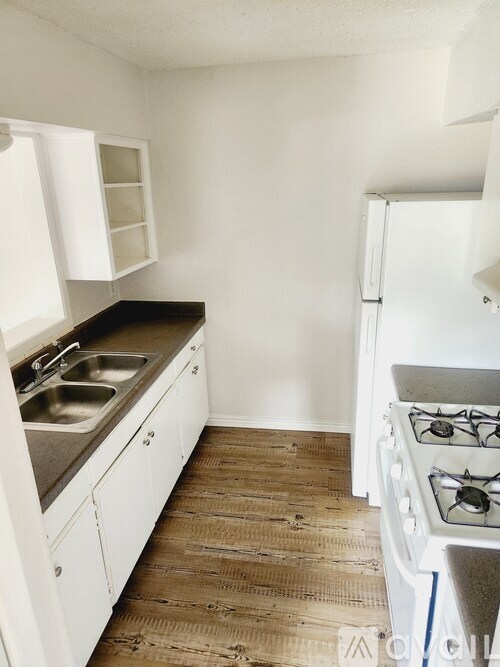 A kitchen with a stove and sink.