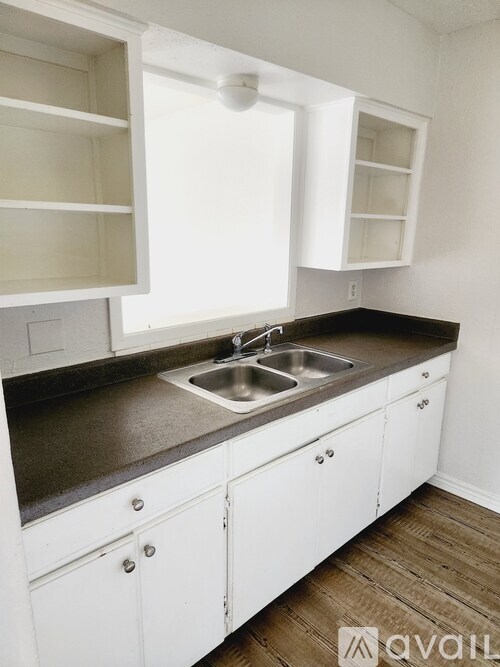A kitchen with white cabinets and a sink.