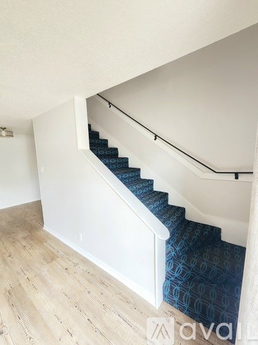 A staircase with a blue carpeted runner.