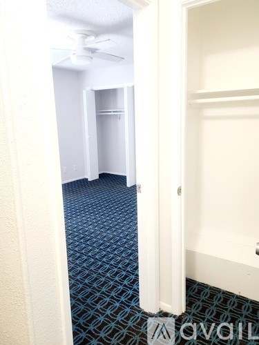 A hallway with a carpeted floor and a door on the right.