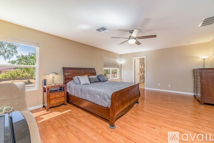 A bedroom with a large bed and a ceiling fan.