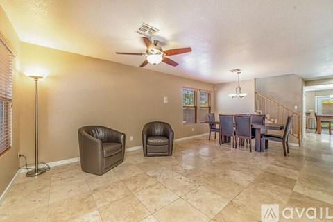 A living room with a brown leather chair and a brown leather armchair.