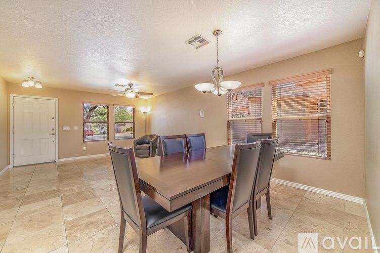 A dining room with a table and chairs.