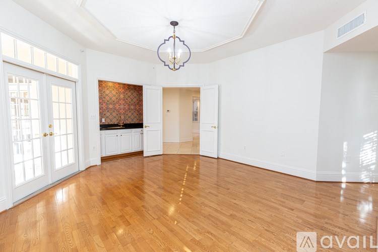 A large empty room with wooden floors and a chandelier.