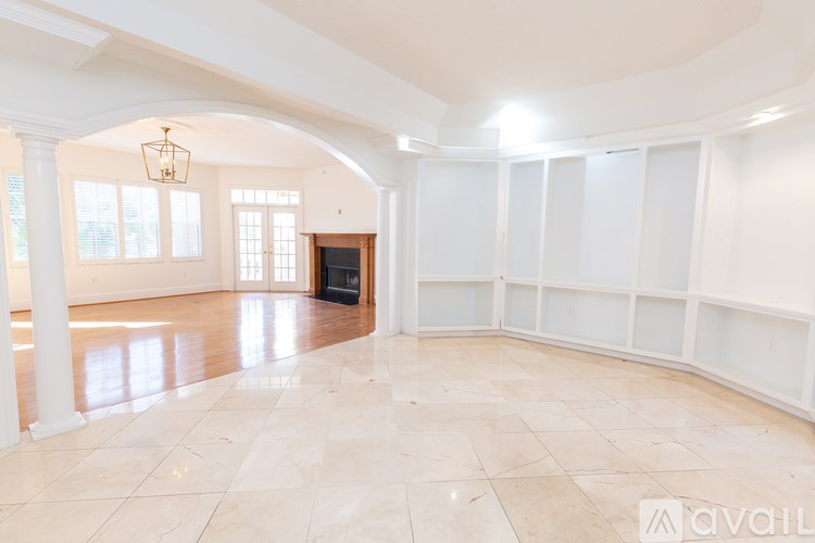 A spacious room with a fireplace and large windows.