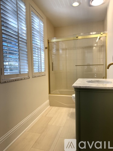 A kitchen with white cabinets and black and white tiles.