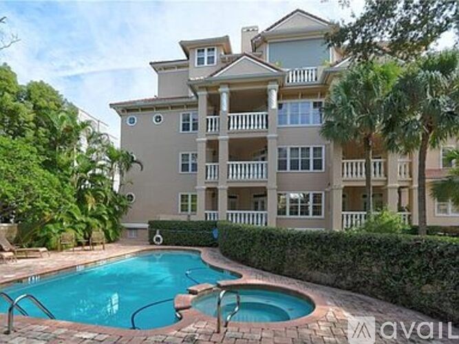 A large apartment complex with a pool in the foreground.
