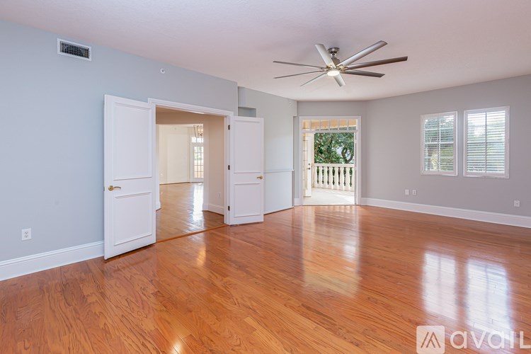A room with wooden floors and a ceiling fan.