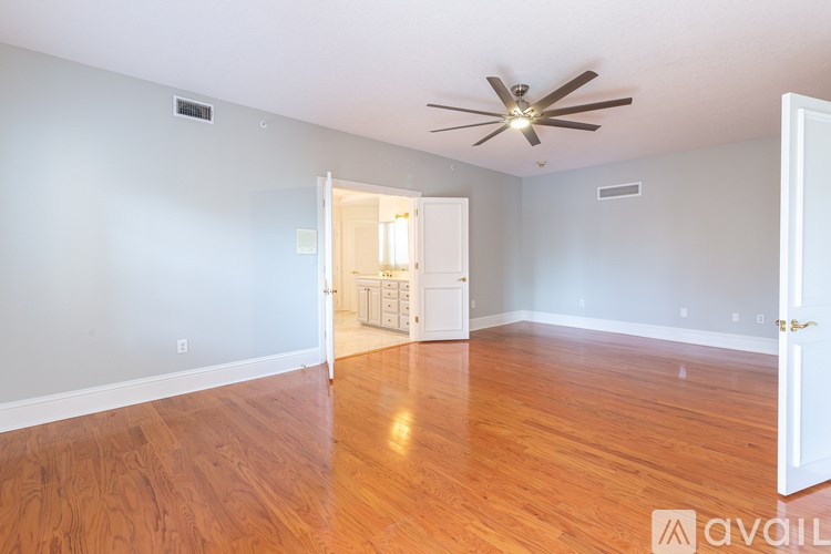 A room with wooden floors and a ceiling fan.