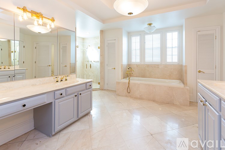 A bathroom with a large mirror, a bathtub, and a sink.