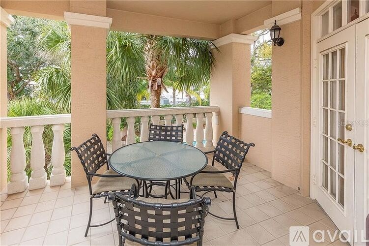 A patio with a glass table surrounded by chairs and a white door.